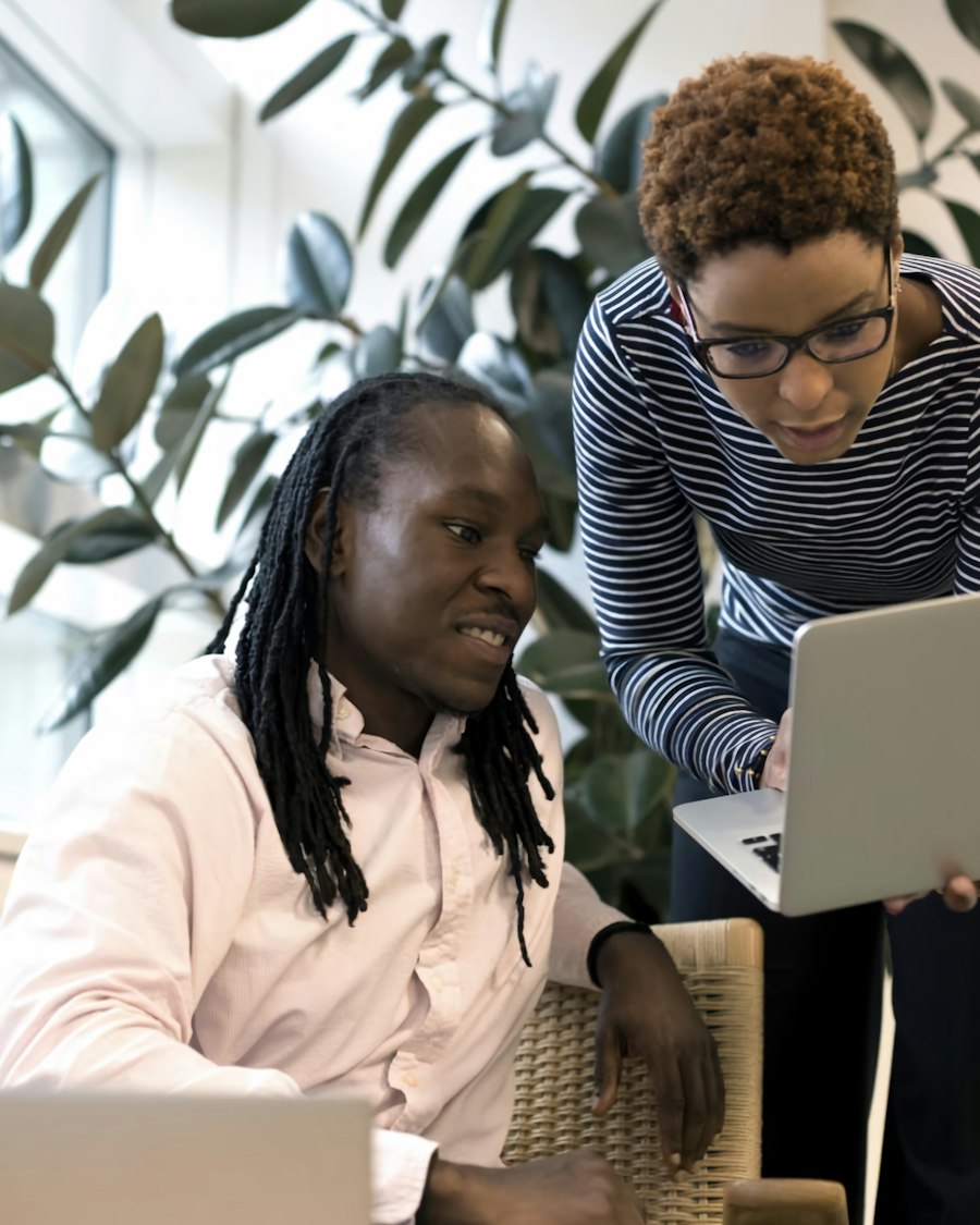 Collègues échangeant autour d'un ordinateur portable dans un bureau